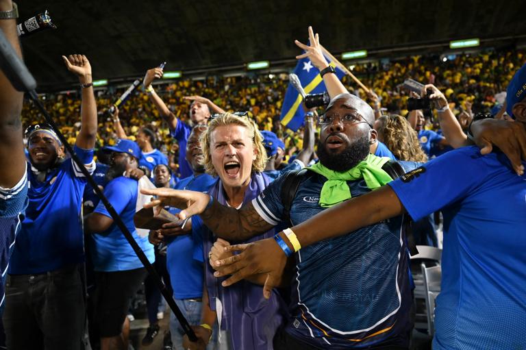 Cura&Atilde;&sect;ao fans celebrate World Cup 2026 qualification after a 0-0 draw with Jamaica at the National Stadium in Kingston, Jamaica on November 18, 2025. The tiny Caribbean nation of Curacao became the smallest country ever to qualify for the World Cup on November 18 as Haiti booked their return to the tournament for the first time in 52 years along with Panama.
A nerve-shredding finale to the CONCACAF qualifying campaign saw Curacao -- with a population of just 156,000 -- squeeze into next year's finals in the United States, Canada and Mexico with a 0-0 draw against Jamaica in Kingston. (Photo by Ricardo MAKYN / AFP) (Photo by RICARDO MAKYN/AFP via Getty Images)          