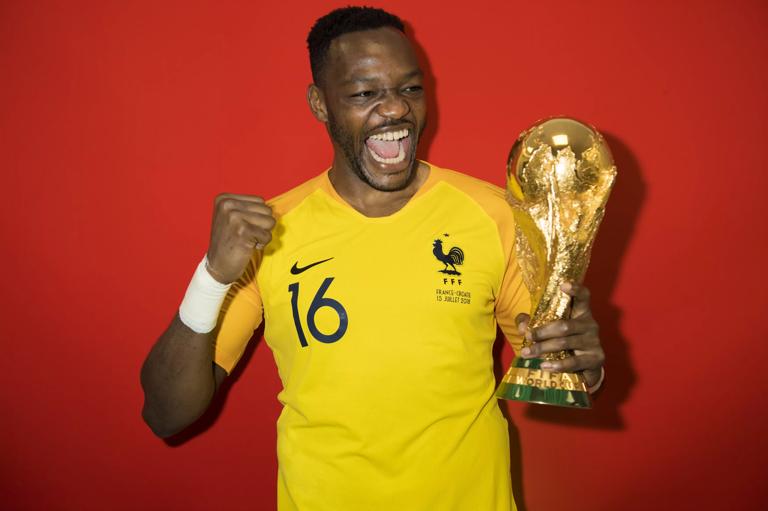 MOSCOW, RUSSIA - JULY 15:  Steve Mandanda of France poses with the Champions World Cup trophy after the 2018 FIFA World Cup Russia Final between France and Croatia at Luzhniki Stadium on July 15, 2018 in Moscow, Russia. (Photo by Michael Regan - FIFA/FIFA via Getty Images)